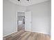 Modern bedroom with wood laminate flooring, and neutral paint; view through door to living space at 8352 Alcona Dr, Indianapolis, IN 46237