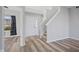 Bright foyer with wood laminate flooring, front door, staircase, and neutral color palette at 8352 Alcona Dr, Indianapolis, IN 46237