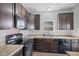 Functional kitchen featuring dark cabinetry, stainless steel appliances, and neutral counters at 8352 Alcona Dr, Indianapolis, IN 46237