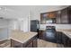Open kitchen and living area featuring an island, dark cabinets, and modern appliances at 8352 Alcona Dr, Indianapolis, IN 46237