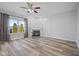 Open living room with a fireplace, a ceiling fan, and large windows for ample light at 8352 Alcona Dr, Indianapolis, IN 46237