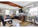 Cozy living room with wood flooring, modern TV and windows providing natural light, creating a warm ambiance at 8657 S Nash Dr, Nineveh, IN 46164