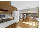 Kitchen with wood cabinets, white appliances, and hardwood floors, next to a breakfast nook at 8831 Lincolncreek Cir, Indianapolis, IN 46234