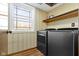 Functional laundry room with modern washer and dryer, storage shelf, and a window at 8831 Lincolncreek Cir, Indianapolis, IN 46234