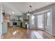 Open kitchen with green cabinets, hardwood floors, stainless steel appliances, and recessed lights at 917 Claiborne Ln, Lebanon, IN 46052
