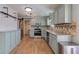 Spacious kitchen with stainless steel appliances, light green cabinets, and hardwood floors at 917 Claiborne Ln, Lebanon, IN 46052