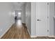 Inviting hallway with wood floors, neutral paint, and white doors leading to various rooms in the home at 9730 Prairie Smoke Dr, Noblesville, IN 46060