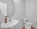 Cozy powder room features a sleek pedestal sink, modern fixtures, and a neutral color palette at 9730 Prairie Smoke Dr, Noblesville, IN 46060