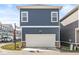 Two-story townhome showcasing a two car garage, and blue siding at 1004 Astor Ln, Carmel, IN 46032