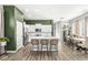 Bright, open kitchen featuring white cabinets, a large island with seating, stainless steel appliances, and wood flooring at 1004 Astor Ln, Carmel, IN 46032