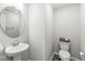 Well-lit powder room with a pedestal sink, modern fixtures, and a decorative touch at 1004 Astor Ln, Carmel, IN 46032