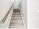 Carpeted staircase with wooden handrail leading to the upper level of the home at 1004 Astor Ln, Carmel, IN 46032