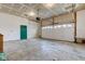 Large garage with concrete floor, a green door, and a rolling garage door at 10046 Gate Dr, Indianapolis, IN 46239