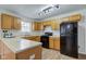 A kitchen featuring wood cabinets, an oven, a refrigerator, a sink, and a window at 10046 Gate Dr, Indianapolis, IN 46239