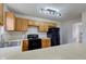 The kitchen has wood cabinets, black appliances, and modern track lighting at 10046 Gate Dr, Indianapolis, IN 46239