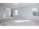 Spacious living room with large windows providing natural light and plush neutral carpeting at 10725 Chenille Ct, Indianapolis, IN 46235