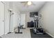 Functional exercise room with elliptical trainer, weight bench, and wall-mounted TV at 12486 Schoolhouse Rd, Fishers, IN 46037