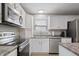Well-lit kitchen with stainless steel appliances and modern white cabinetry at 12486 Schoolhouse Rd, Fishers, IN 46037