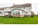 This backyard features a large green lawn, a sunroom with large windows, and a pergola-covered patio at 12624 Teaberry Ln, Carmel, IN 46032