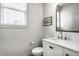 Elegant half bath with a marble vanity, modern faucet, and classic mirror at 12624 Teaberry Ln, Carmel, IN 46032