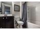 Well-lit bathroom featuring a dark vanity, a toilet, and a shower-tub combination at 12624 Teaberry Ln, Carmel, IN 46032