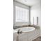 Bright bathroom features a soaking tub with tile surround and natural light at 12624 Teaberry Ln, Carmel, IN 46032