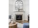 Modern fireplace with decorative mantle, arched mirror, and tiled hearth at 12624 Teaberry Ln, Carmel, IN 46032