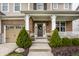 Welcoming front door with wreath, flanked by manicured evergreens at 12624 Teaberry Ln, Carmel, IN 46032