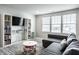 Comfortable living room with large windows, a gray couch, and built in shelving for storage at 12624 Teaberry Ln, Carmel, IN 46032