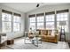 Cozy living room showcasing a tan leather sofa, neutral rug and plenty of natural light at 12624 Teaberry Ln, Carmel, IN 46032