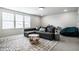 Cozy living room with a comfortable gray couch, a patterned rug, and bright natural light at 12624 Teaberry Ln, Carmel, IN 46032
