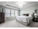 Calm main bedroom showcasing a plush bed, tray ceilings, and large windows for ample sunlight at 12624 Teaberry Ln, Carmel, IN 46032