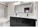 Bright bathroom featuring dual sinks, modern vanity with drawers, and tiled shower with a subway tile design at 1434 S Talbott St, Indianapolis, IN 46225
