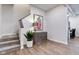 Inviting entryway with wood floors, staircase, and stylish accent cabinet with a decorative lamp and painting at 1434 S Talbott St, Indianapolis, IN 46225