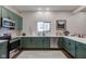 Stylish kitchen showcasing stainless steel appliances, green cabinetry, and white countertops, illuminated by recessed lighting at 1434 S Talbott St, Indianapolis, IN 46225