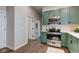 Bright kitchen featuring green cabinets, stainless steel appliances, and a doorway to the living room at 1434 S Talbott St, Indianapolis, IN 46225