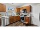 Functional kitchen with stainless steel appliances, wooden cabinets, and a window providing natural light at 15214 Ten Point Dr, Noblesville, IN 46060