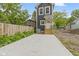 View of backyard with a concrete patio, wood fence and a dark gray house with white trim at 1538 Ringgold Ave, Indianapolis, IN 46203
