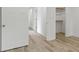 Hallway with multiple doors and closets with wood-look floors and white trim at 1538 Ringgold Ave, Indianapolis, IN 46203