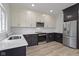 Kitchen features stainless steel appliances, white cabinets, and hardwood floors at 1538 Ringgold Ave, Indianapolis, IN 46203
