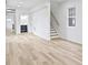 Open-concept living room with light wood-look floors, white walls, a staircase, and natural light at 1538 Ringgold Ave, Indianapolis, IN 46203