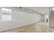 Spacious living room with light wood-look floors, bright white walls, large windows, and a staircase at 1538 Ringgold Ave, Indianapolis, IN 46203
