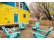 Charming backyard featuring a gravel area with comfortable seating and a colorful yellow house with a bright blue door at 1647 N Tacoma Ave, Indianapolis, IN 46218