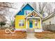 Charming two-story home featuring a peaked roof, inviting front porch, and a vibrant yellow and blue color scheme at 1647 N Tacoma Ave, Indianapolis, IN 46218