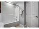 Bathroom featuring white tub and shower, grey walls, tile floor and white door at 1805 Braeburn Dr, Carmel, IN 46032