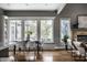 Open dining room with large windows, built-in bench, stone fireplace, and light hardwood floors at 1805 Braeburn Dr, Carmel, IN 46032
