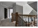 Upstairs hallway featuring wood and wrought iron banister with view of foyer chandelier at 1805 Braeburn Dr, Carmel, IN 46032