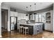 Modern kitchen featuring white cabinets, a gray island with seating, and stainless steel appliances at 1805 Braeburn Dr, Carmel, IN 46032