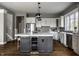 Open kitchen with island, wine fridge, white cabinets, and view to the outside at 1805 Braeburn Dr, Carmel, IN 46032