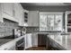 Bright kitchen with white cabinetry, stainless steel appliances, and mosaic backsplash tiles at 1805 Braeburn Dr, Carmel, IN 46032